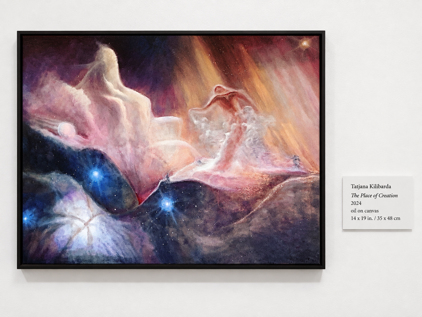 The Place of Creation displayed on a gallery wall beside its exhibition label.