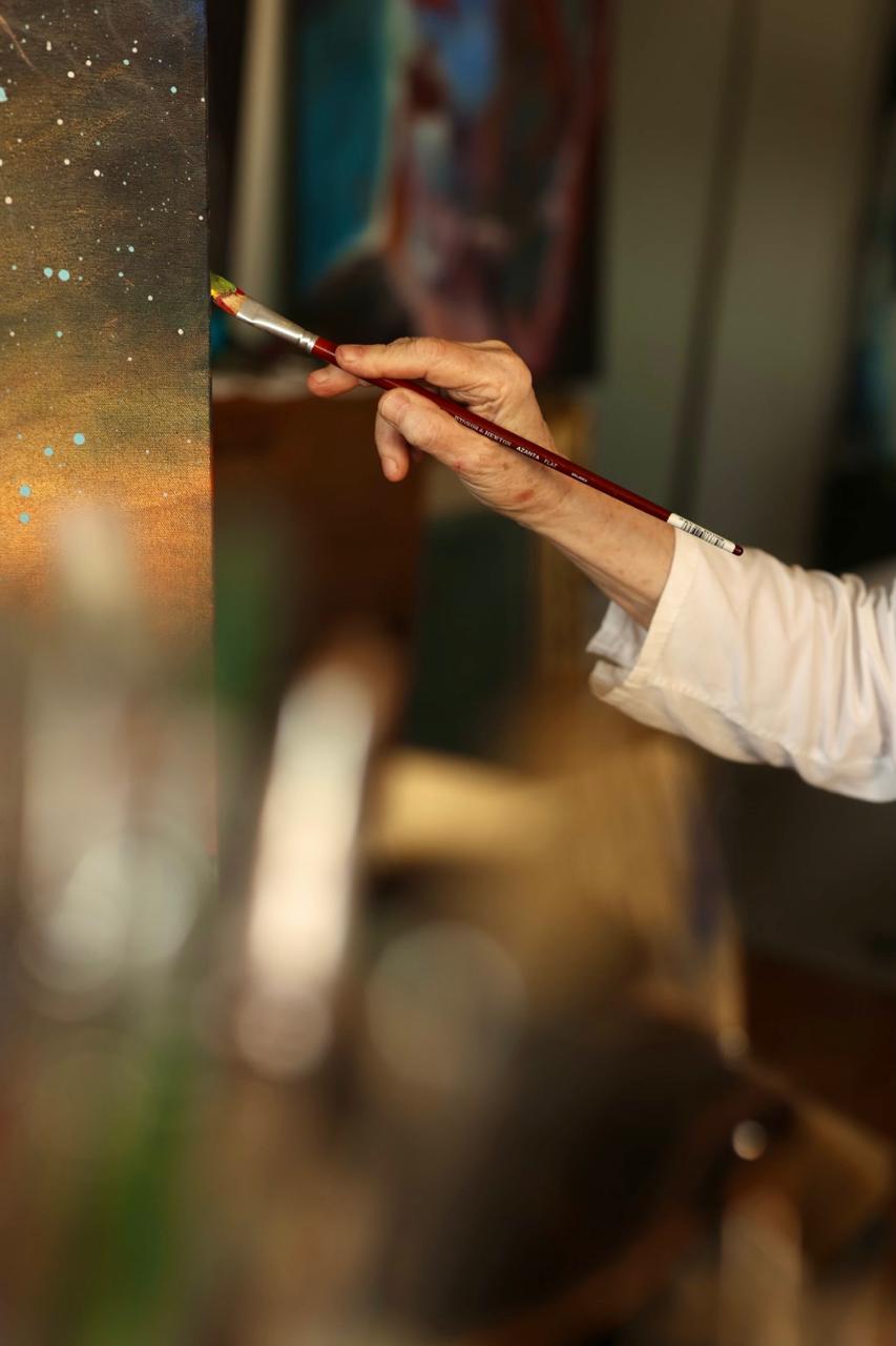 Tatjana Kilibarda applying paint to a canvas in her studio.